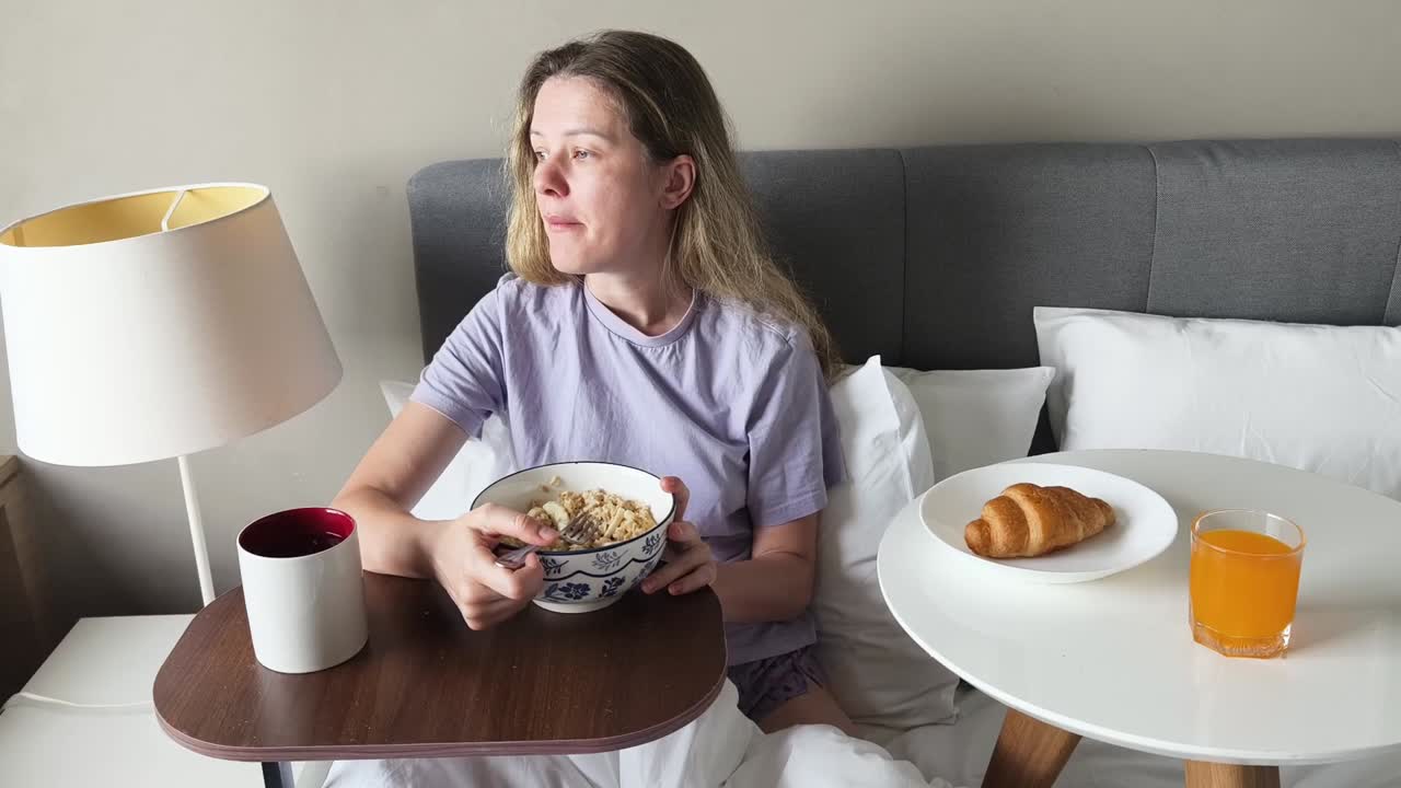 침대에서 아침을 먹는 여자