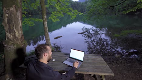 businessman talking by phone against the lake.