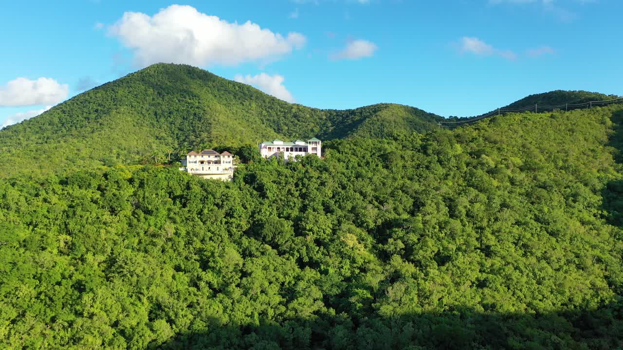 Drone footage soars above interior St. Croix, where a handful of private vacation homes rest quietly among thick jungle, winding hills, and soft Caribbean peaks rising into the island skyline