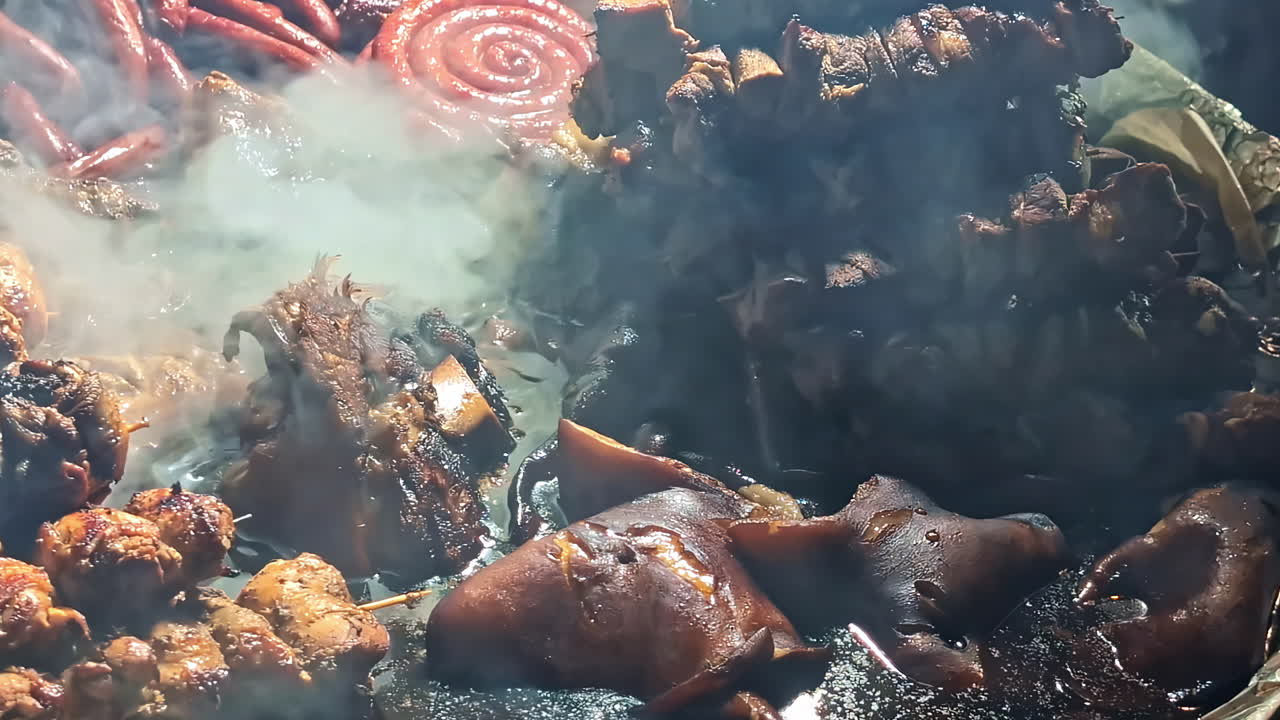 Outdoor cooking of skewers and meat boiling in fire pit with smoke and flames under night sky