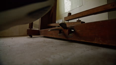 medium wide shot of pressing the pedals of an old broken piano