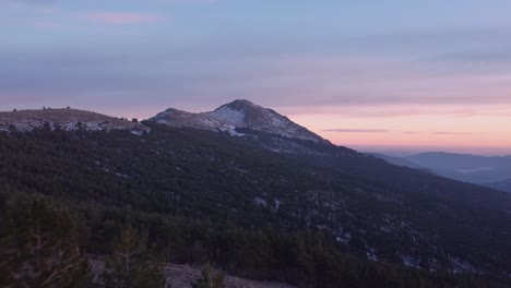 low aerial forward view during sunset in winter with snow on mountain peaks in madrid, spain