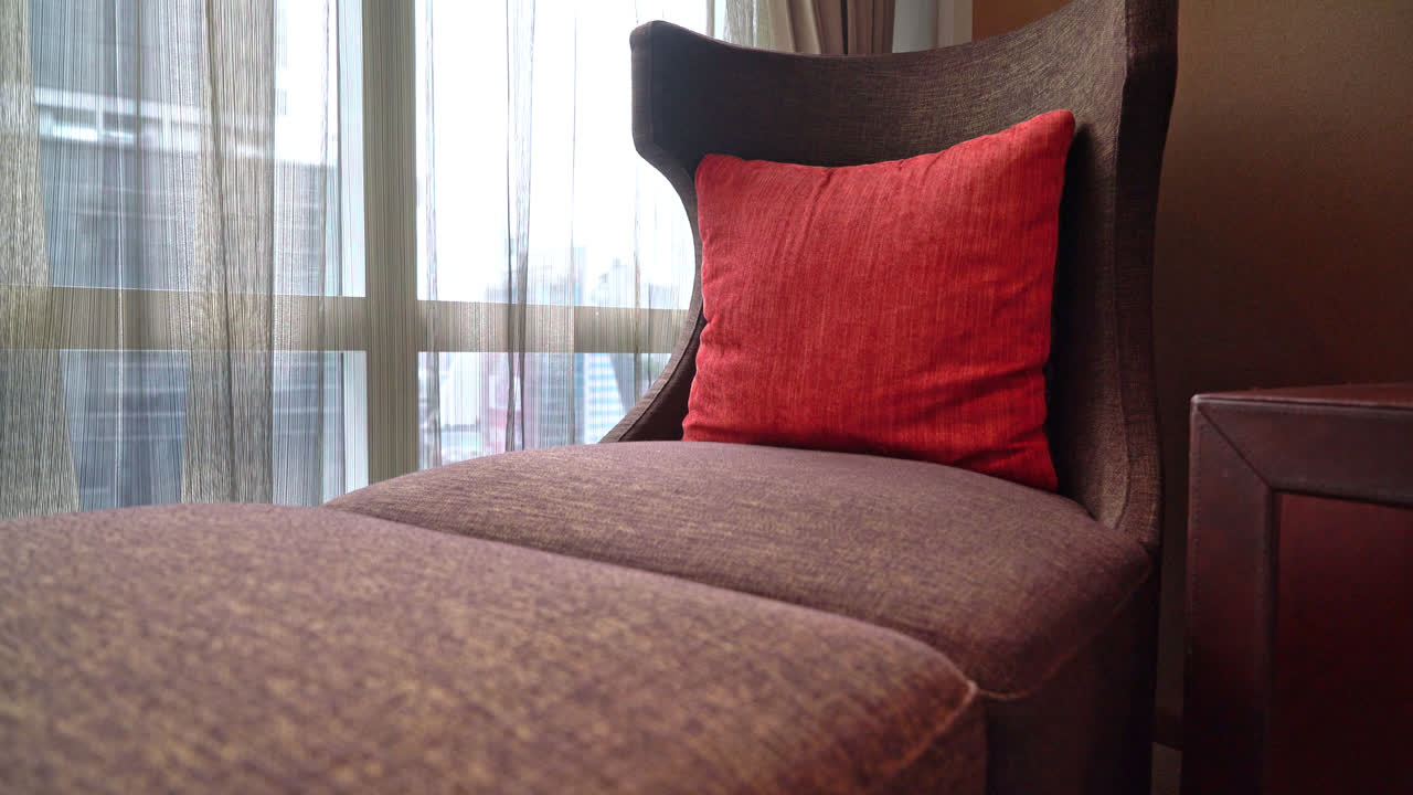 창문 근처의 침대 겸용 소파에 베개