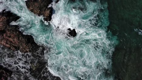 turbulent waves crashing against rocky shores of corralejo, fuerteventura in the canary islands, aerial view