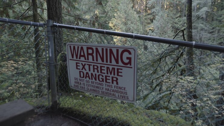 Cartello di pericolo estremo su recinzione vicino a una scogliera a Lynn Valley