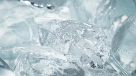 alcoholic aperitif vodka or gin pouring over ice cubes in macro and slow motion