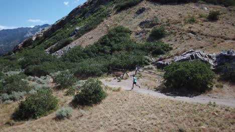 disparo de un dron siguiendo a un hombre activo corriendo por los senderos de montaña al aire libre de wasatch sobre draper city, utah