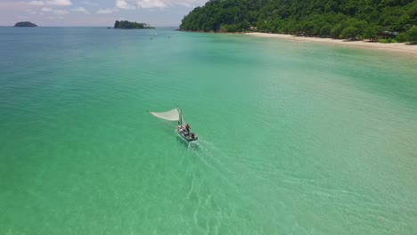 dolly-tilt-down-Aerial-shot-of-a-traditional-shrimp-fisherman-on-small-wooden-boat-in-Thailand-with-beach-and-islands-in-the-background
