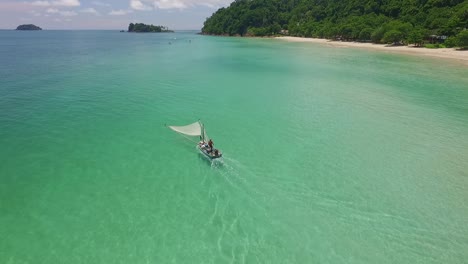 Dolly-Incline-Hacia-Abajo-La-Toma-Aérea-De-Un-Pescador-Tradicional-De-Camarones-En-Un-Pequeño-Bote-De-Madera-En-Tailandia-Con-Playa-E-Islas-En-El-Fondo