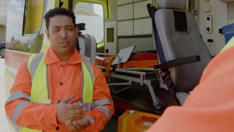 two medical assistants talking in front of an ambulance 2