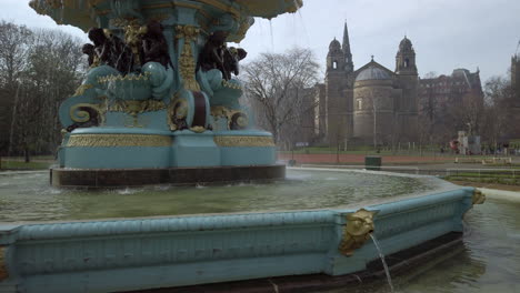 Pan-up-Ross-Fountain-in-Princes-Street-gardens-with-The-Parish-Church-of-St-Cuthbert-in-the-background-on-a-sunny-day,-Edinburgh,-Scotland