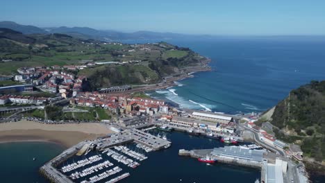 Panorámica-Aérea-Sobre-El-Horizonte-Azul-Del-Océano,-Ciudad-De-Getaria-En-La-Costa-De-España