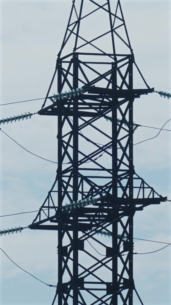 Close up view of a high voltage electricity transmission tower and power lines