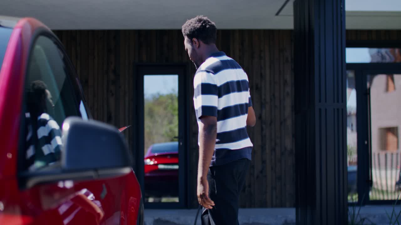 Man Charging Electric Car at Home