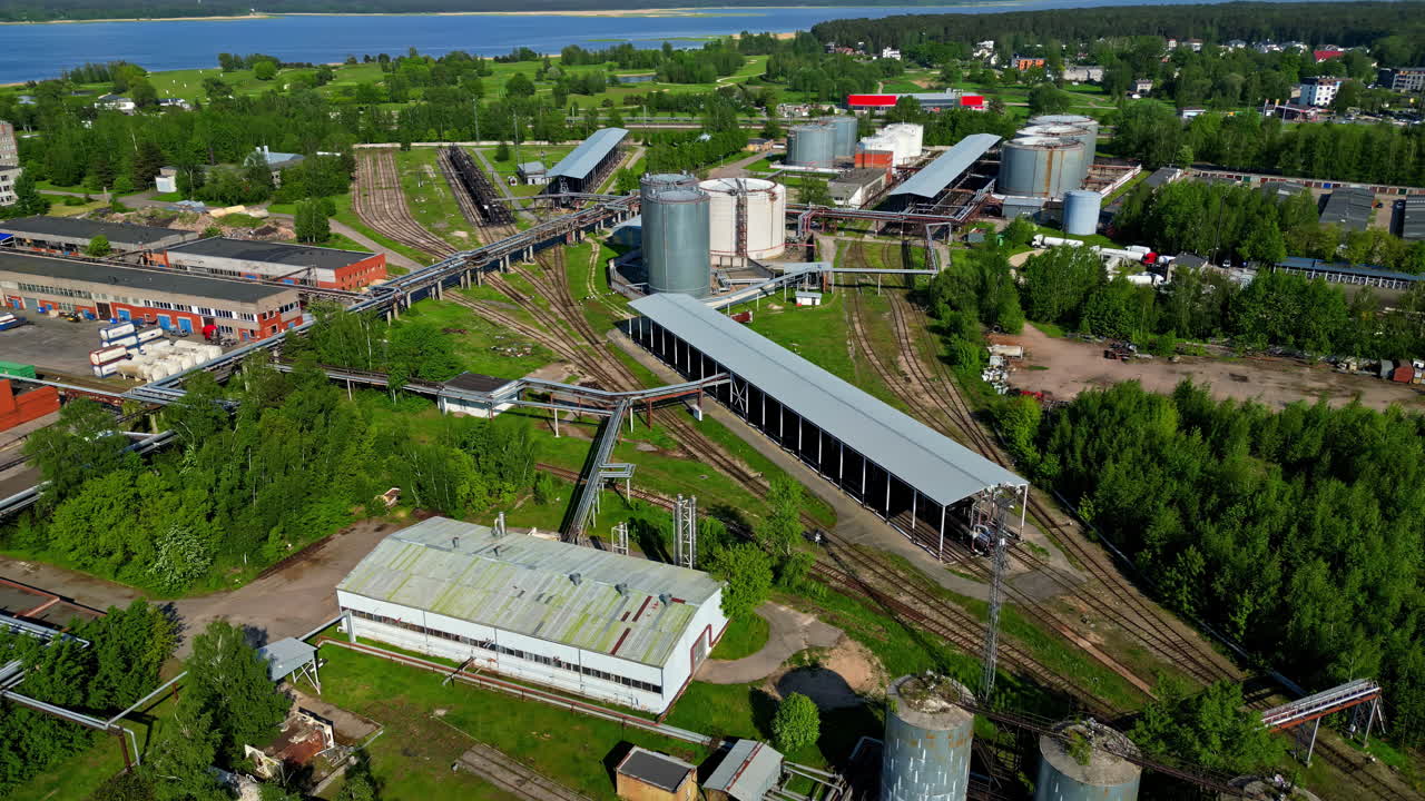 Aerial drone forward moving shot over train standing in a railway station shed beside a railway station on a sunny day