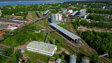 Aerial-drone-forward-moving-shot-over-train-standing-in-a-railway-station-shed-beside-a-railway-station-on-a-sunny-day