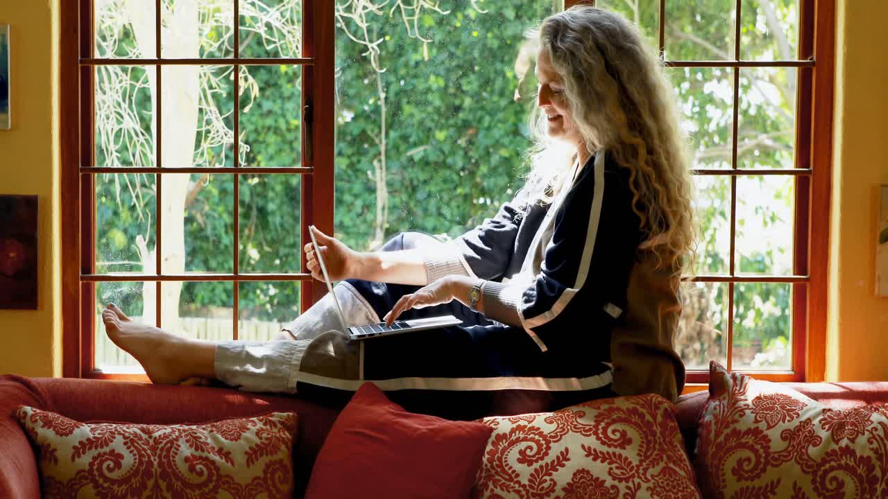 윈도우 4k 근처에 노트북을 사용하는 성숙한 여성