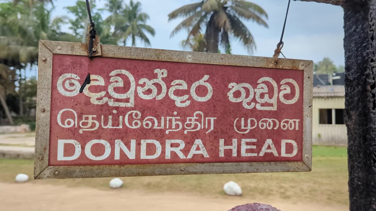 Closeup of Dondra Head Lighthouse sign at southernmost point in English, Tamil, and Sinhala languages