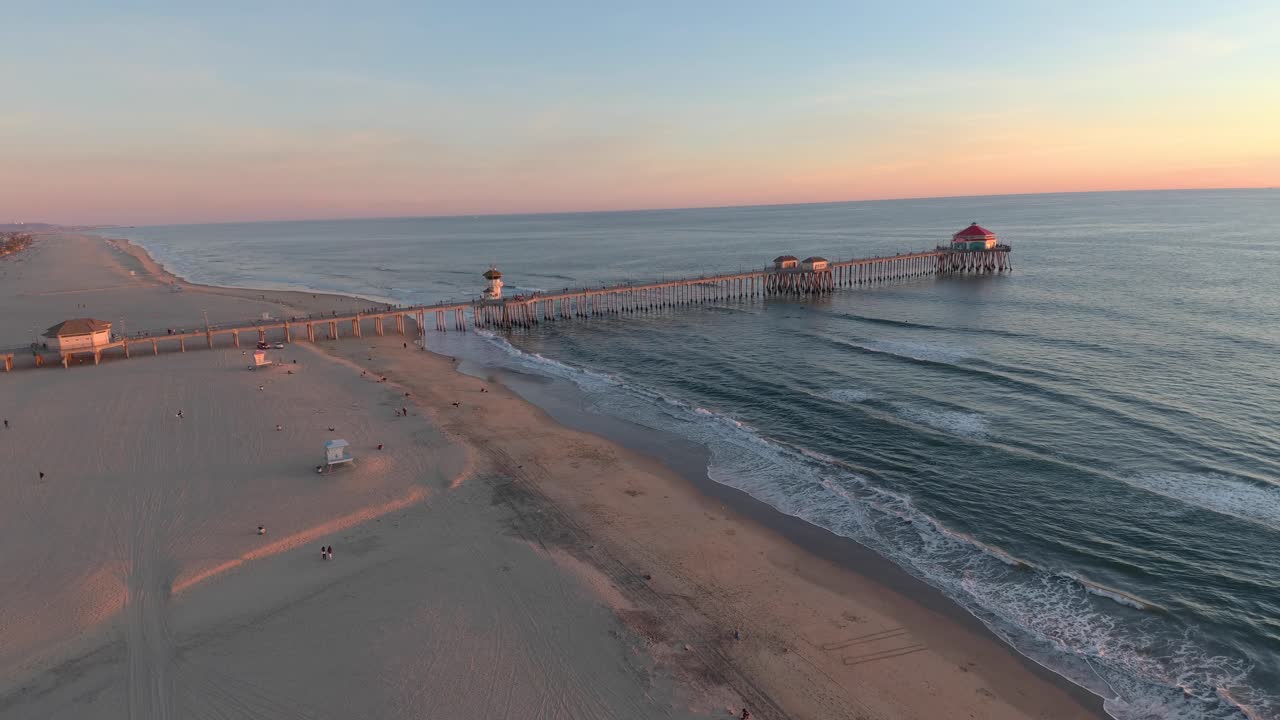 беспилотник пролетает высоко над пляжем, показывая пирс пляжа хантингтон в городе серф-сити в южной калифорнии