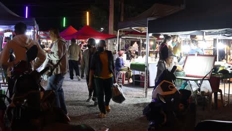 personas navegando por los puestos en un vibrante mercado nocturno