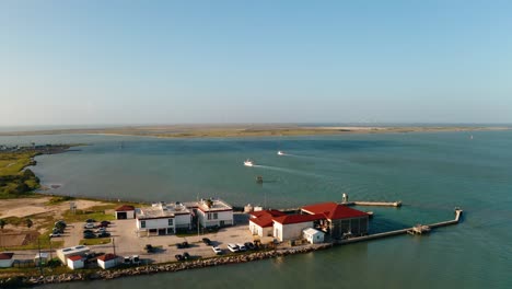 Aerial-drone-push-in-over-harbor-of-ships-leaving-South-Padre-Island-bay-inlet-for-open-ocean