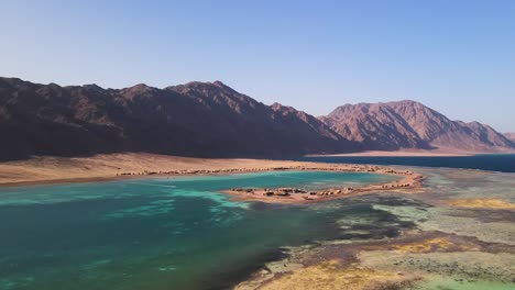 La-Vista-Aérea-De-La-Laguna-Azul-En-Dahab,-Egipto,-Ofrece-Vistas-Inspiradoras-Del-Paisaje-Desértico-Circundante,-Prometiendo-A-Los-Visitantes-Una-Experiencia-Incomparable-E-Inolvidable.