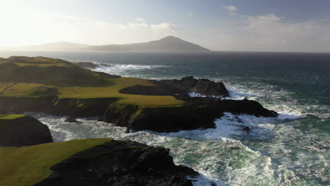 Cinematic-drone-shot-of-the-ocean-waves-hitting-the-rocky-coastline-at-the-White-Cliffs-of-Ashleam,-Ireland