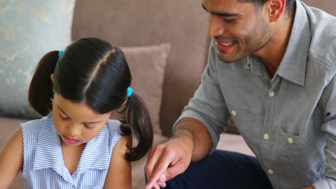 padre ayudando a su hija con su proyecto escolar