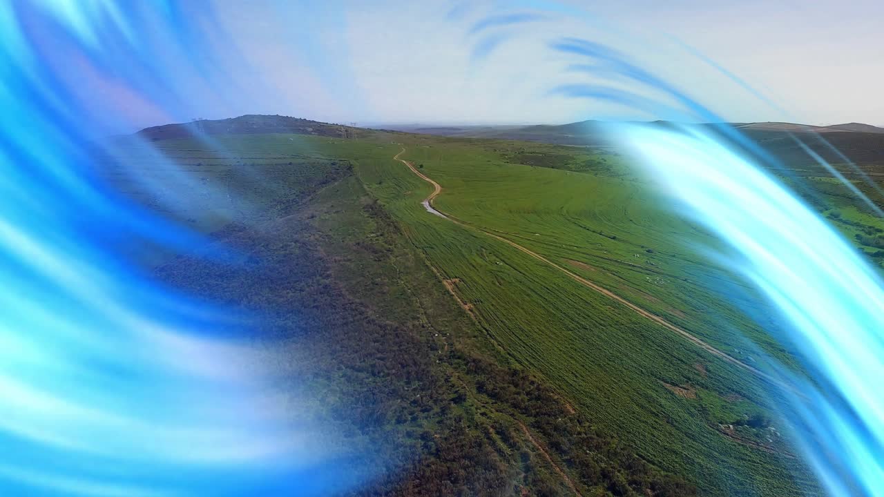 fields with winding road receiving blue ribbons beginning sweeping, receding to highlight terrain