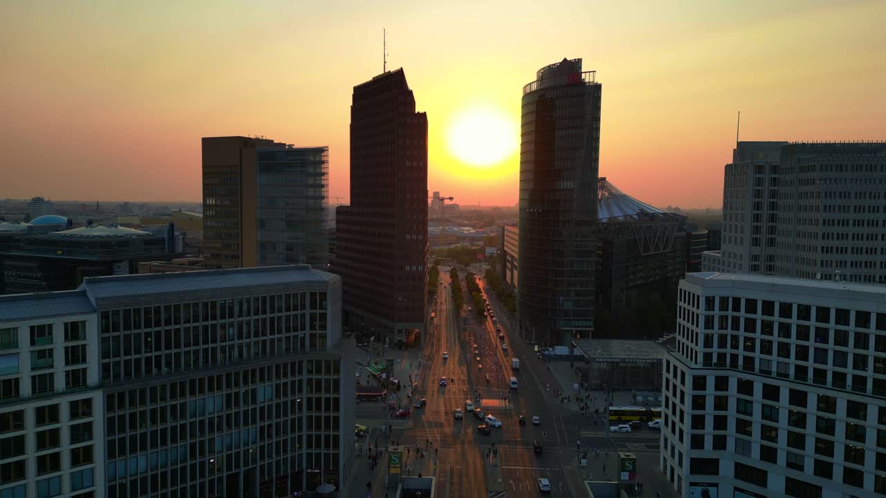 Berlin potsdamer platz skyline during golden hour sunset with traffic flowing on roads. Beautiful aerial view flight drone shot footage from above