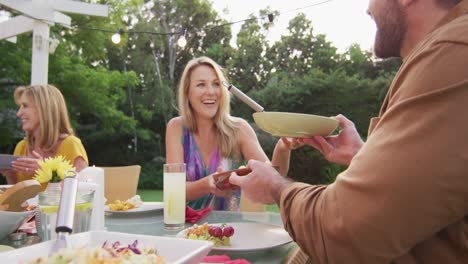 familia de tres generaciones disfrutando del almuerzo al aire libre