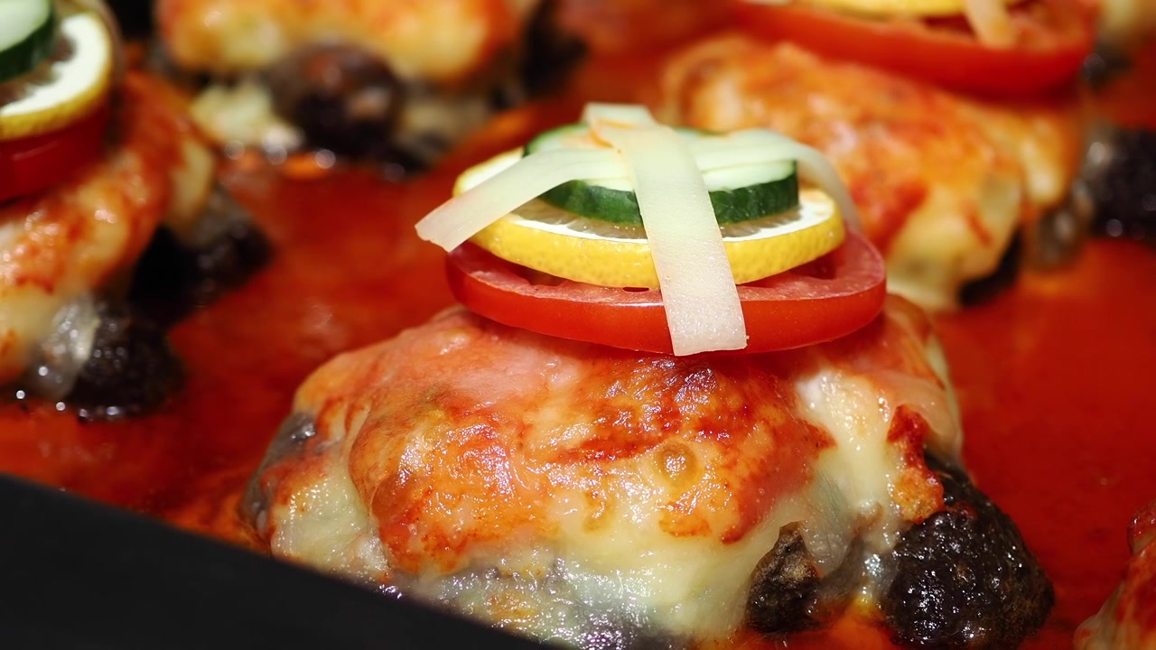 Pollo al forno guarnito con pomodoro, cetriolo e formaggio fuso.