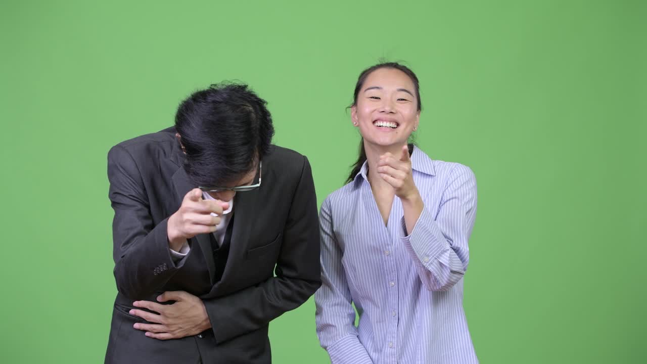 Young Asian business couple laughing together