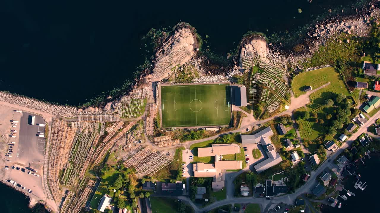 Top-down view of Henningsvaer iconic soccer field on a rocky island surrounded by ocean at Lofoten, Norway.