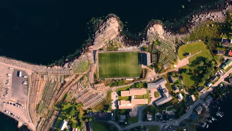 top-down view of henningsvaer iconic soccer field on a rocky island surrounded by ocean at lofoten, norway.