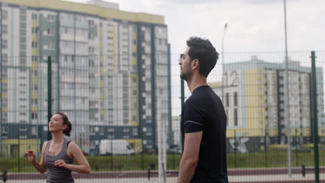 asian woman and arabic man hitting a volleyball