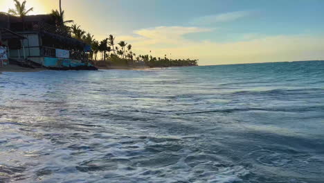 panning-shot-from-seaside-beach-vendors-to-the-ocean's-breaking-waves-in-Punta-Cana,-Dominican,-Hispaniola