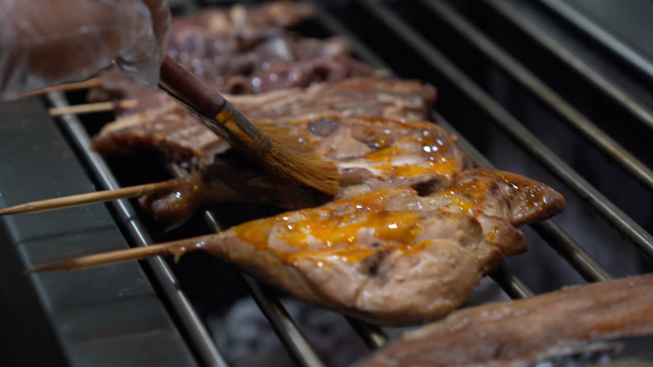 바베큐 그릴에서 마리네이드 소스와 함께  ⁇ 고기 부분을  ⁇ 는 것