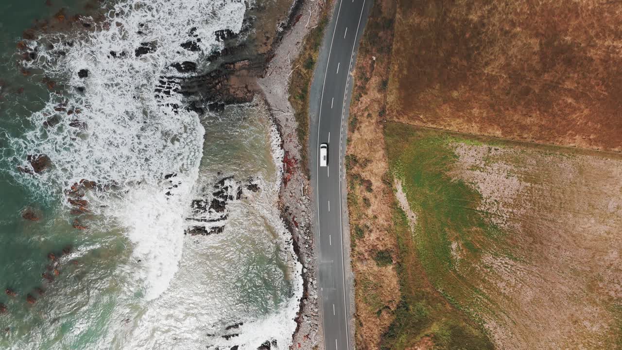 tomada de un avión no tripulado de una furgoneta que conduce a lo largo del océano en la bahía de molyneux cerca de kaka point en la región de otago de nueva zelanda