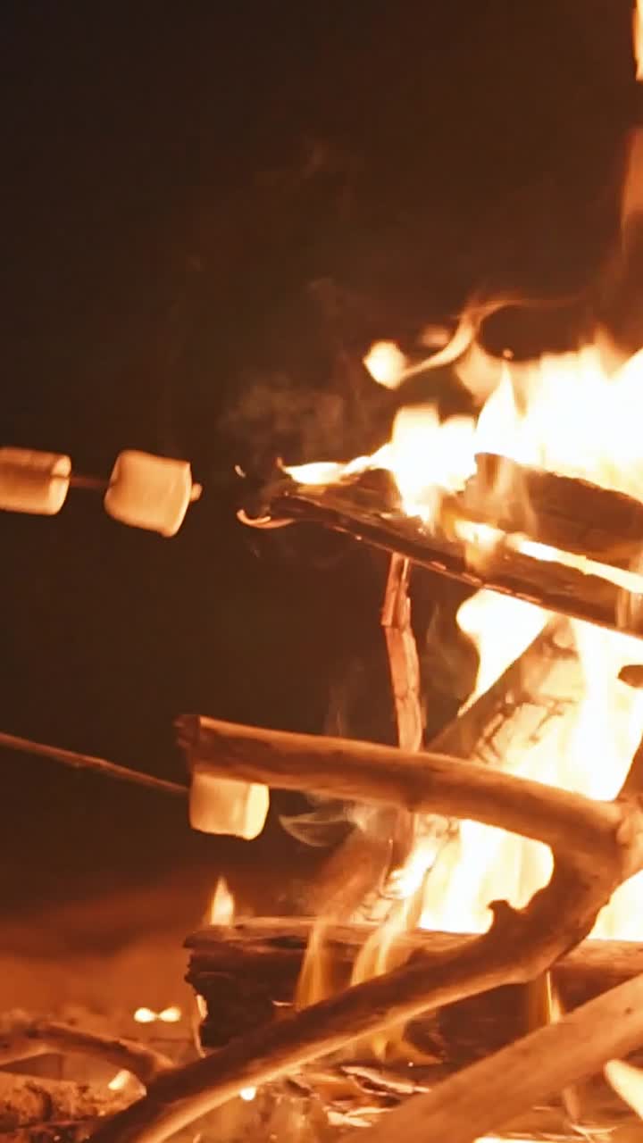 Marshmallows on sticks near fire at rest stop for travelers going on hike