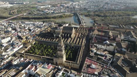 aerial  backwards view over magnificent city of cordoba, with its cathedral-mosque and the old roman bridge over river guadalquivir. andalucia, spain