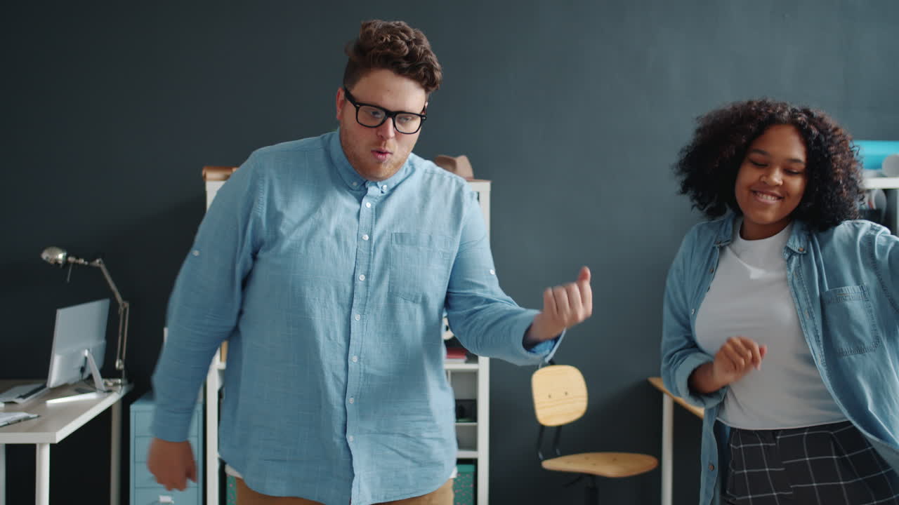 Two colleagues dancing in an office