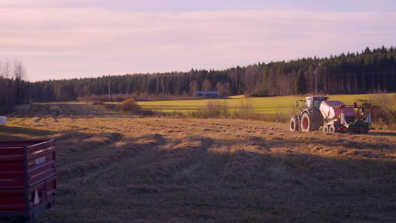 스웨덴 소데르함에서 햇볕이 잘 드는 가을 저녁 시골에 있는 밀밭에서 수확하는 트랙터를 따라 돌리 샷