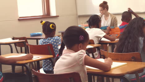 cute pupil smiling at camera in classroom