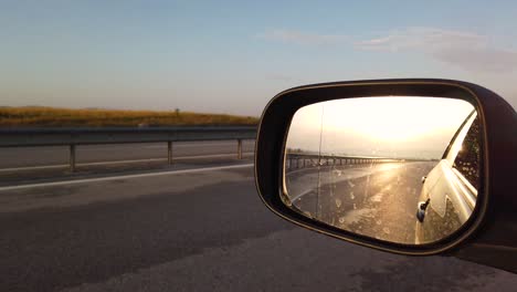 espejo retrovisor lateral de reflexión por la mañana en la carretera al atardecer o al amanecer