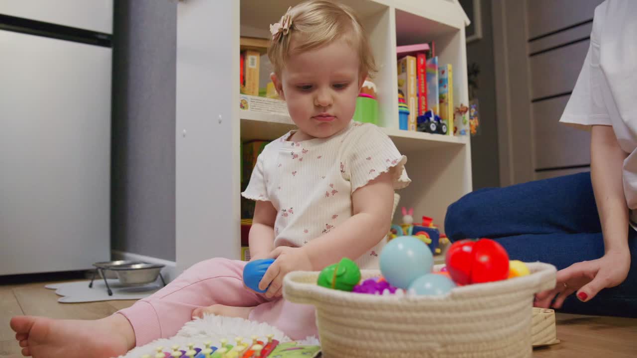 Cute Toddler Girl Playing with Colorful Toys on the Floor