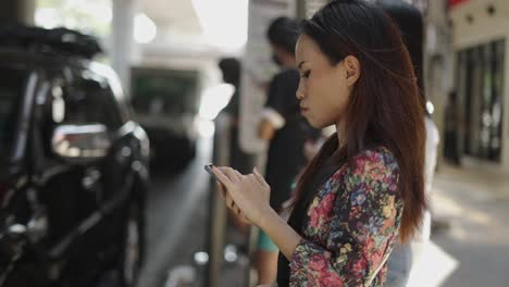 a woman using her smartphone outdoors on a city street
