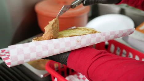 extendiendo una salsa picante en un bollo - serie de camiones de comida