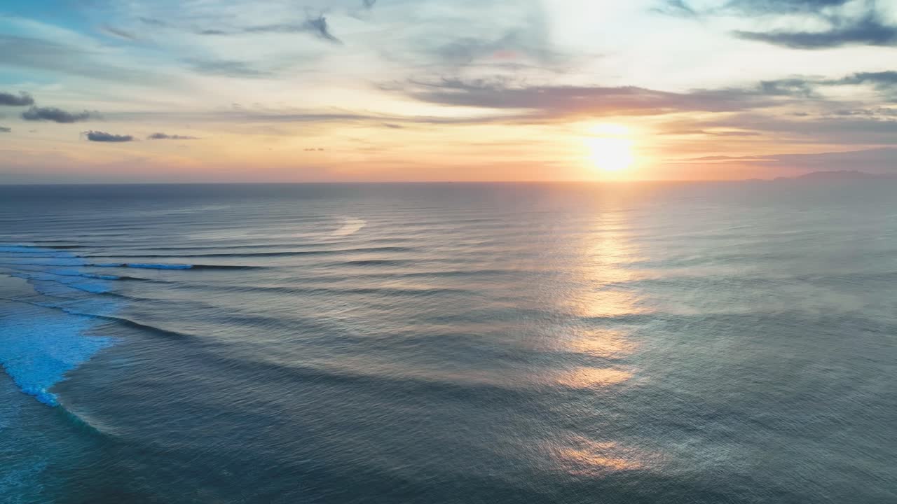 아름다운 황금빛 일몰의 고정 드론  ⁇  오픈 파란 바다에서 지평선에 부드럽게 포장 파도와 화이트 워터