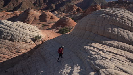 excursionista femenina en la ruta de senderismo yant flat candy cliffs, utah, ee.uu., caminando cuesta arriba sobre formaciones únicas de arenisca